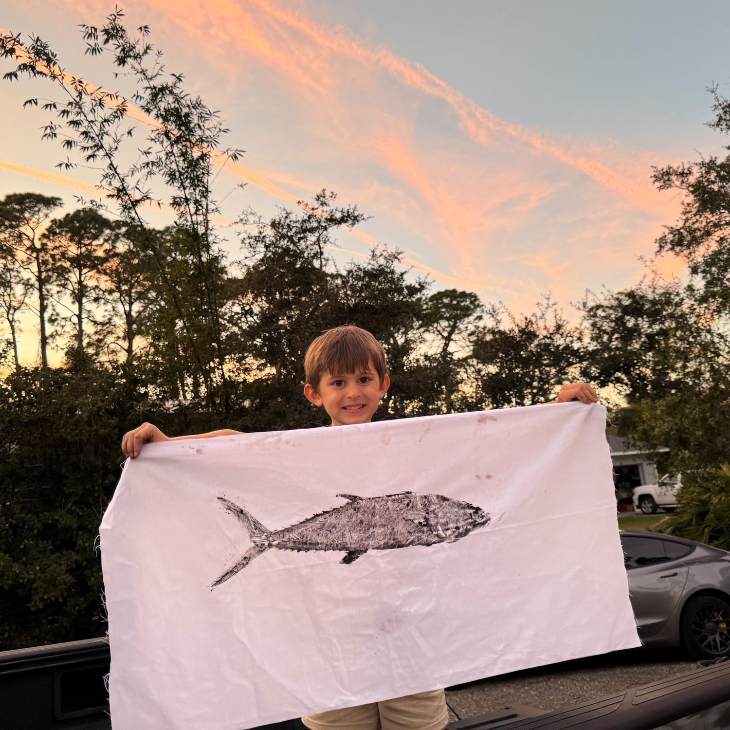 young angler holding a fishing print he made for his dad as a gift for fathers day
