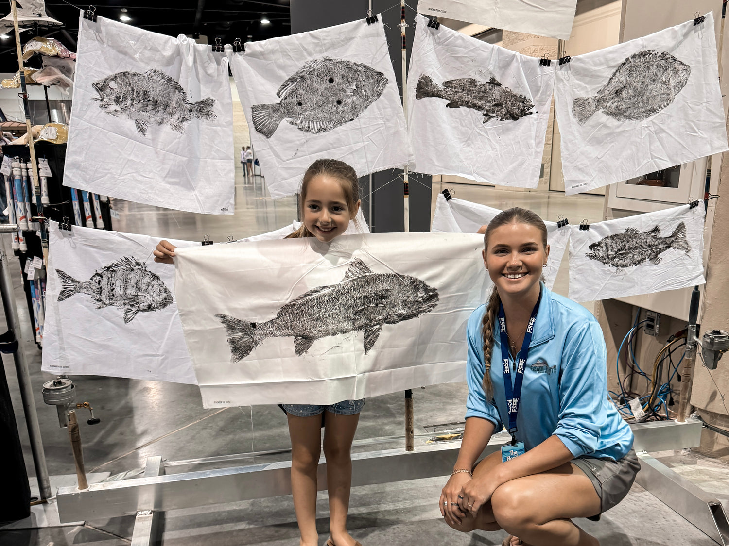 young angler holding a fishing print of a redfish at a The Florida Saltwater Fishing Expo